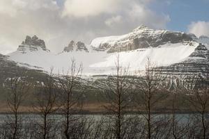 het prachtige landschap uitzicht op de bergen in stodvarfjordur de vissersstad in de oostelijke regio van ijsland. Oost-IJsland heeft adembenemende fjorden en charmante vissersdorpjes. foto