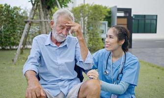 depressieve mannelijke patiënt huilen op rolstoel. jonge verpleegster die hem troost. ongelukkige senior man met geriatrische of depressieve ziekte. therapeut zorgzaam, ondersteunend en empathisch. foto