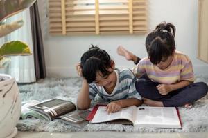 geconcentreerde broers en zussen die een boek lezen foto