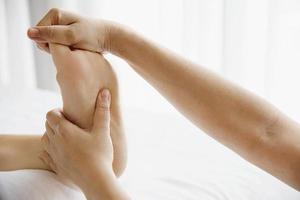 vrouw die voetmassage krijgt van masseuse close-up bij hand en voet - ontspan in voetmassage therapie dienstverleningsconcept foto