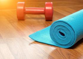 blauwe yogamat en rode dumbbell foto