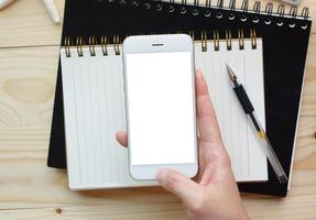 vrouw handen met leeg scherm van smartphone op houten bureau werk. foto