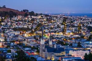 kerk op de voorgrond en glooiende heuvels van San Francisco en puntige daken foto
