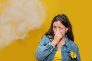 tienermeisje knijpt in haar neus omdat giftige dampen van auto, slechte geur, luchtvervuiling, stofallergieën of sinusinfectie, vrouwelijke tiener die neus wrijven lijdt aan allergie in de stad, het leven van stedelijke mensen. foto