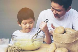 papa en zoon maken graag aardappelpuree foto