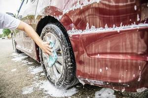 man wast auto met shampoo - autoverzorgingsconcept voor het dagelijks leven foto