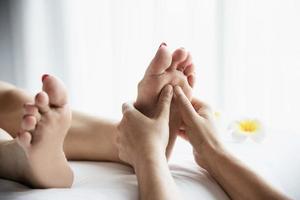 vrouw die voetmassage krijgt van masseuse close-up bij hand en voet - ontspan in voetmassage therapie dienstverleningsconcept foto