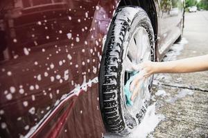 man wast auto met shampoo - autoverzorgingsconcept voor het dagelijks leven foto