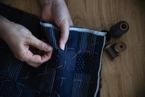 vintage vrouw naaien doek met de hand met borduurwerk ingesteld op houten tafel achtergrond - mensen en handgemaakte diy huishoudelijk werk concept foto