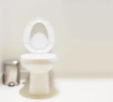 soft focus flush toilet en zilveren bak in witte heldere toiletruimte - schone toiletruimte maaggezondheid achtergrondconcept foto