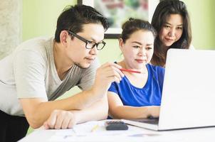 twee vrouwen en een man werken mee op de computer in een modern kantoor foto