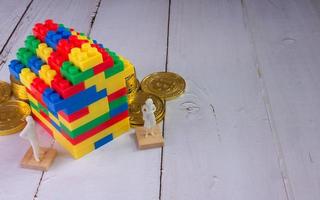 thuis veelkleurige speelgoedbaksteen en gouden munten voor bedrijfsconcept voor kinderen of onroerend goed foto