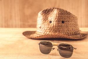zonnebril en hoed op de houten tafel foto