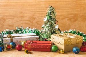 geschenkdozen met kerstversiering op houten tafel achtergrond. foto