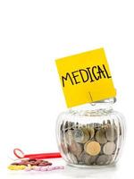 munten in glazen fles met medicijnen op witte achtergrond, geld besparen voor medische foto