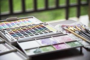 paletdoos voor waterkleuren met set penselen - uitrusting voor het schilderen van waterkleuren voor gebruik op de achtergrond foto