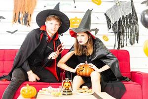 gelukkig halloween-feestconcept. jonge man en vrouw die als vampieren, heks of geest dragen, vieren het halloween-festival foto