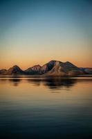 bergen over meer bij zonsondergang foto