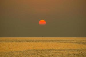 hij zon viel in de avond. glanzende gouden kleur, als gevolg van het zeewater foto