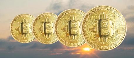 bitcoin-munten op de achtergrond van de zonsonderganghemel met de zon foto