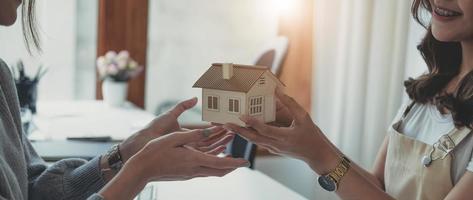 makelaar om huis en land te kopen levert huis aan klant na akkoord te gaan met het maken van een overeenkomst voor de aankoop van een huis. foto