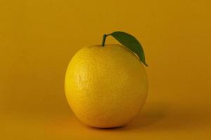 sappige citroen geïsoleerd op gele achtergrond. een citroen gebruikt voor gezond fruit conceptontwerp, sinaasappelfruit met sinaasappelschijfjes en blad geïsoleerd op gele achtergrond foto