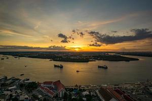 vogelperspectief van samut prakan, thailand. zonsondergang over de chao phraya-rivier, oranje lucht. foto