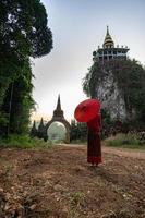 vrouwen in Thaise klederdracht met de rode paraplu die voor de hoofdingang staat, de tijd van wachten, het beeld uit het verleden, de vertaling van de tijdpoort aan de deur is de naam putthawadee foto