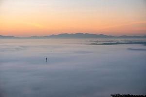 ochtendmist bedekt lamphun, thailand, uitzicht vanuit het gezichtspunt van wat phra that pha-tempel foto