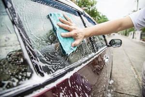 man wast auto met shampoo - autoverzorgingsconcept voor het dagelijks leven foto