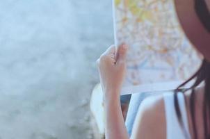 toeristische reisvrouw die naar de kaart kijkt terwijl ze op straat loopt - straatrugzakreisconcept foto