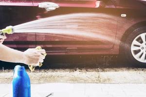 man bereidt shampoowater voor voor het wassen van de auto - thuis mensen auto schoon concept foto