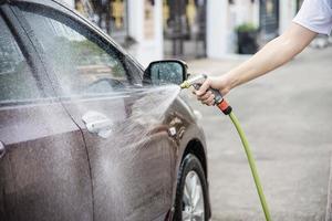 man wast auto met shampoo - autoverzorgingsconcept voor het dagelijks leven foto
