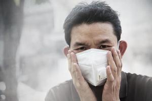 man met masker beschermt fijn stof in luchtvervuilingsomgeving - mensen met beschermingsuitrusting voor luchtvervuilingsconcept foto