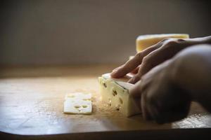 vrouw die kaas bereidt voor koken met kaasrasp in de keuken - mensen die voedsel maken met kaasconcept foto