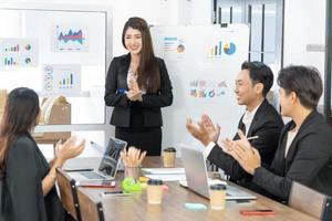 mooie zakenvrouw geeft verslag, presentatie aan haar zakelijke collega's in de vergaderruimte, ze toont afbeeldingen. succesvolle vrouwelijke zakelijke professional. foto