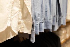 selectieve focus, mode, kledingconcept, kleding of broek veel kleuren hangen op een plank in een merkkledingwinkel. veel pastelkleurig foto