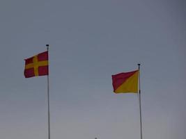 kleurrijke vlaggen wapperen in de wind over blauwe lucht foto
