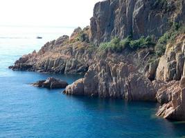 rotsen en kliffen met blauwe lucht en turquoise zee foto