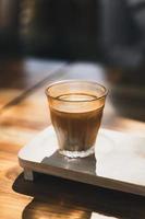 een glas espresso geschoten over koude verse melk. vuile koffie, koffiemenu, melkkoffie foto
