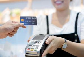 klant in café betaalt via creditcard aan winkelbediende foto