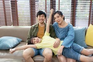 portret van een gelukkige Aziatische familie die samen tijd doorbrengt op de bank in de woonkamer. familie en huis concept. foto