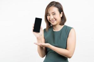 jonge aziatische vrouw die smartphoneschot toont dat op witte achtergrond wordt geïsoleerd foto