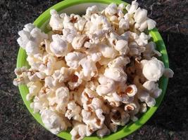 hoog zicht op rijpe popcorn geserveerd in groene bowl.close up. Naast het helpen van je afvallen, heeft het eten van popcorn ook andere gezondheidsvoordelen. foto