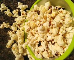 hoog zicht op rijpe popcorn geserveerd in groene bowl.close up. Naast het helpen van je afvallen, heeft het eten van popcorn ook andere gezondheidsvoordelen. foto