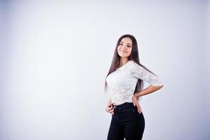 portret van een elegante jonge vrouw in witte top en zwarte broek in de studio. foto