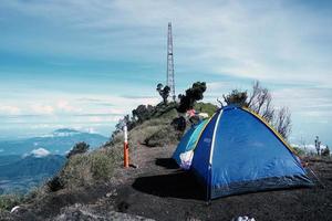tent op de top van de berg op een zonnige dag met een telecommunicatietoren op de achtergrond foto