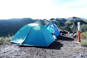 bergbeklimmen tent met groene bergen achtergrond bedekt met wolken foto