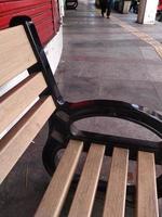 openbare voorziening. houten stoel op een stoep. rustplaats voor voetgangers. foto