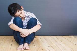 Aziatische jongen van 7 jaar voelt zich verdrietig foto